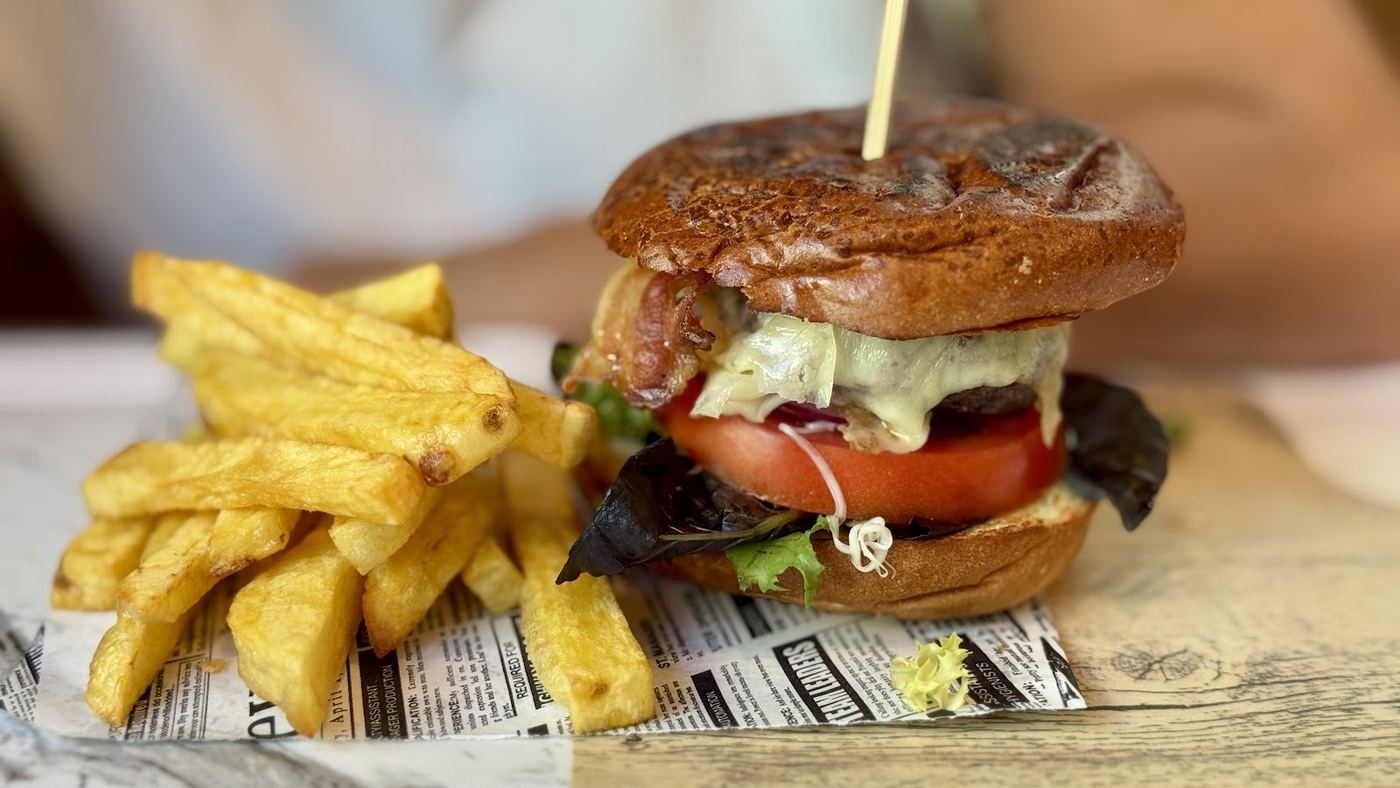Hamburguesa completa con queso, bacon y patatas fritas caseras, servida en el Restaurante Esmeraldas